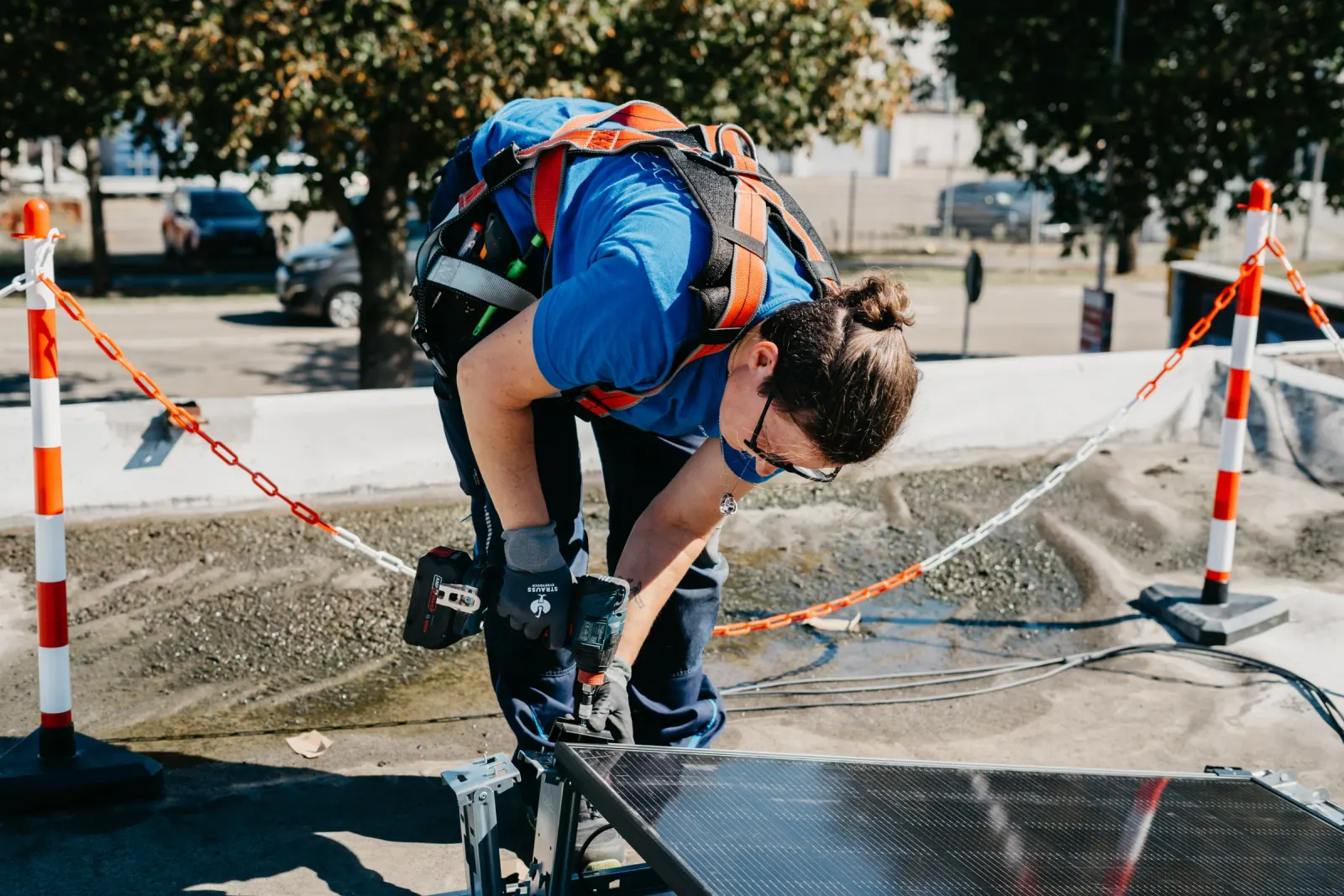 Monteurin verschraubt ein Solarmodul auf einer Unterkonstruktion