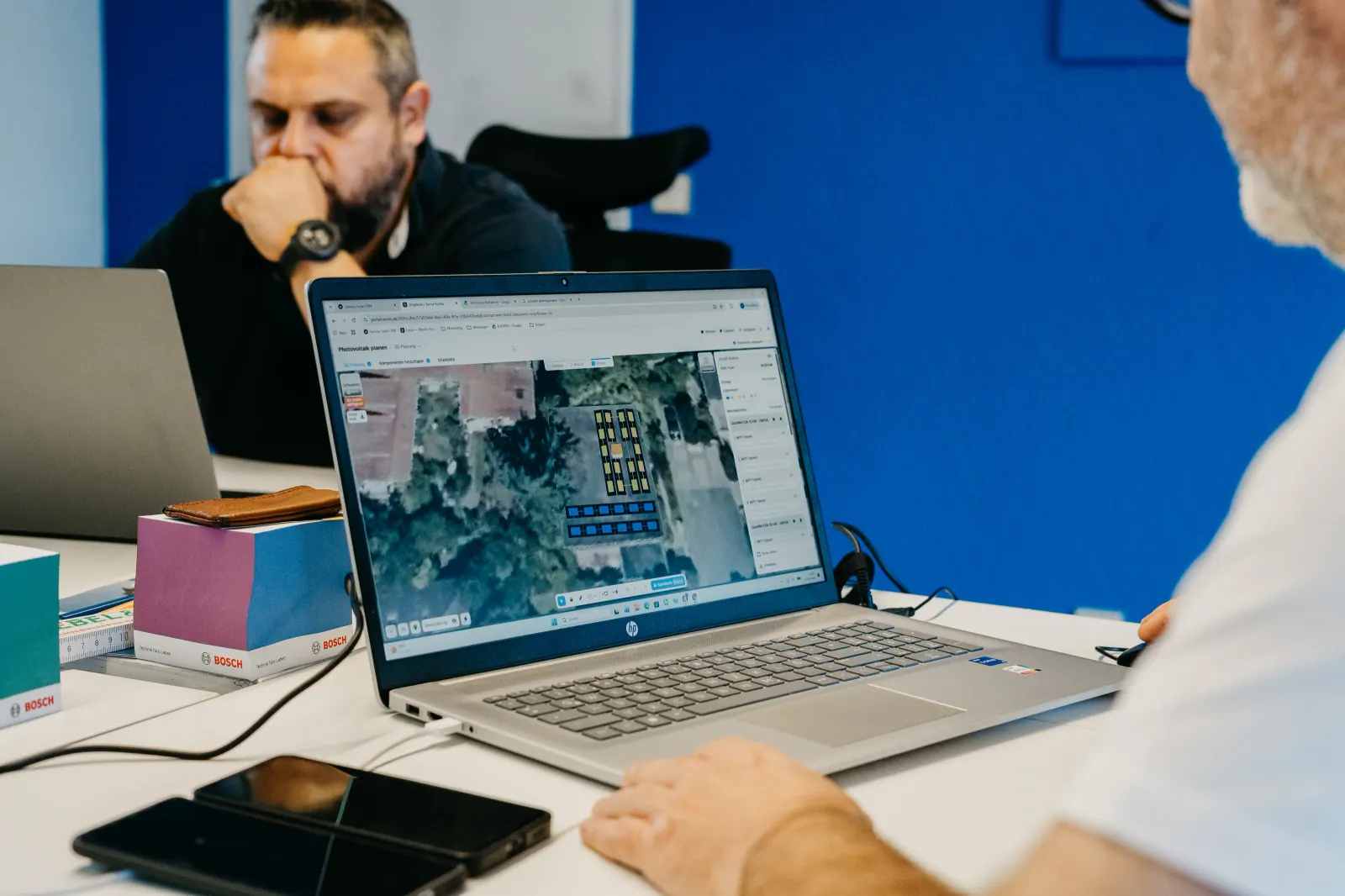 Zwei Personen planen eine Photovoltaikanlage am Laptop
